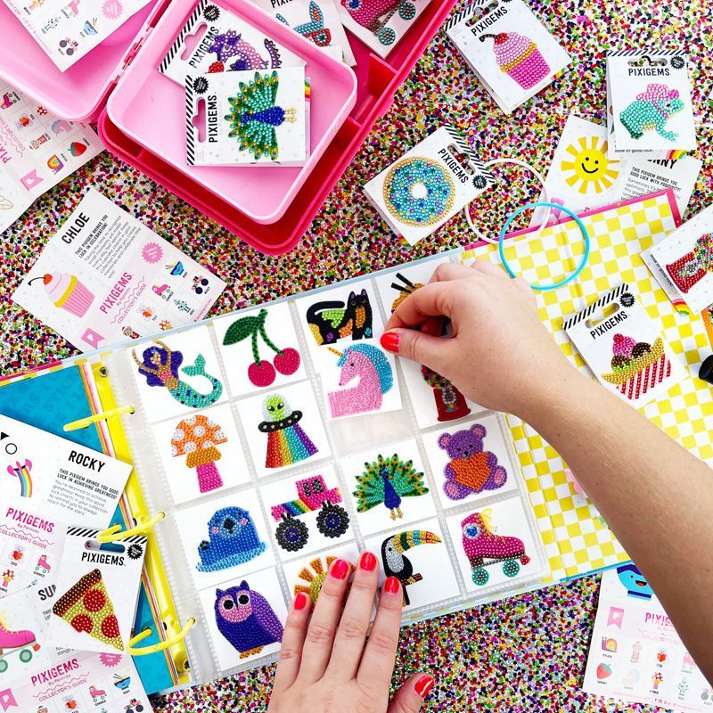 Colorful pegboard with various shaped pegs and a hand interacting with them on a multicolored surface.