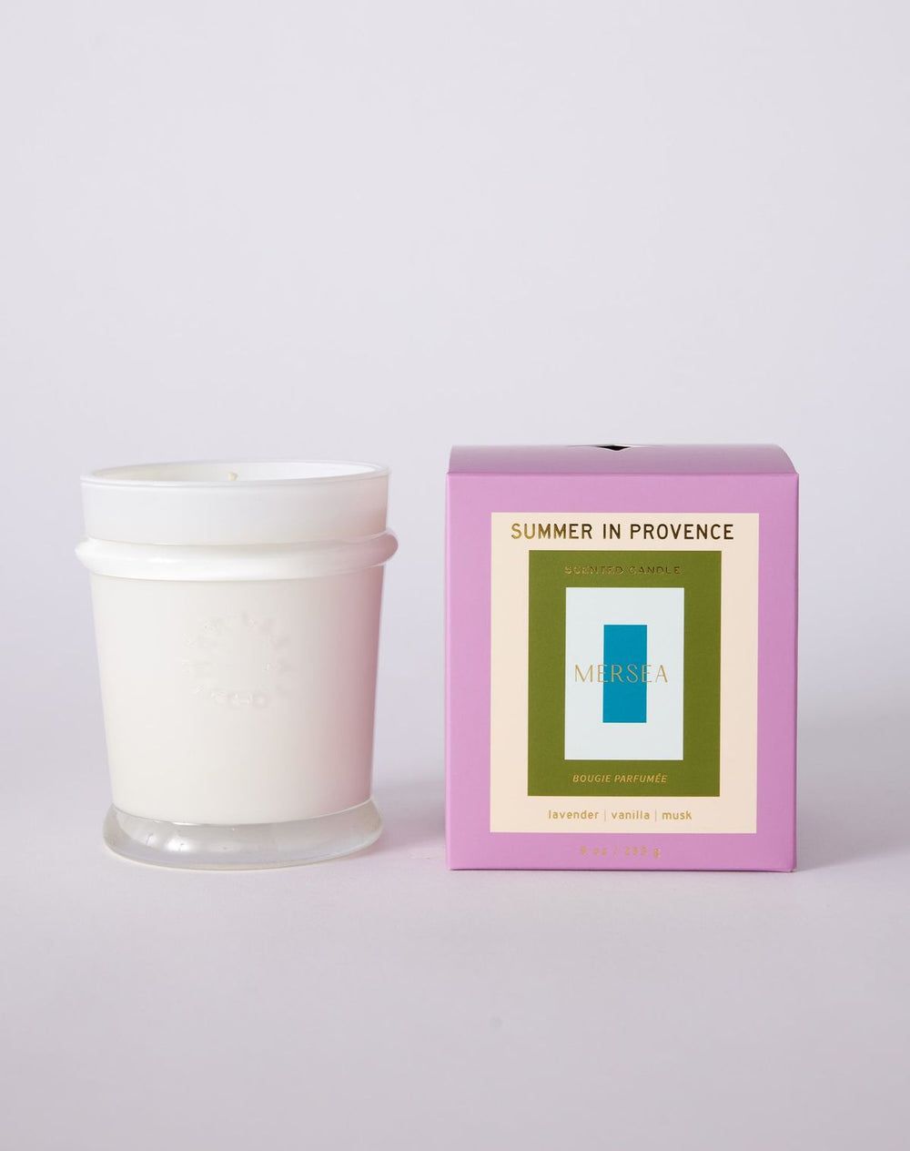 White candle with a pink box labeled 'Summer in Provence' on a light purple background