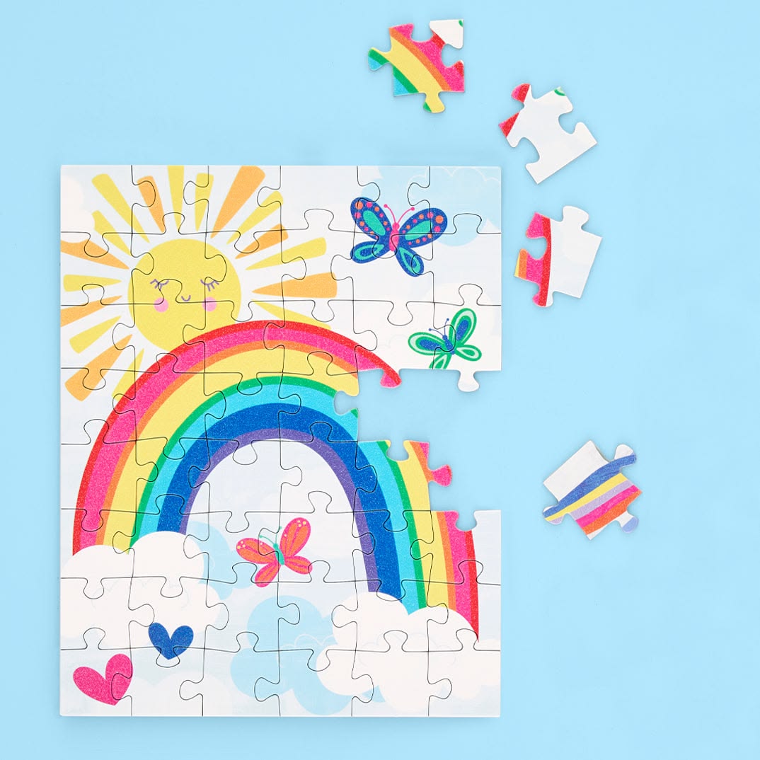 Children's puzzle with a rainbow, sun, and butterflies on a blue background