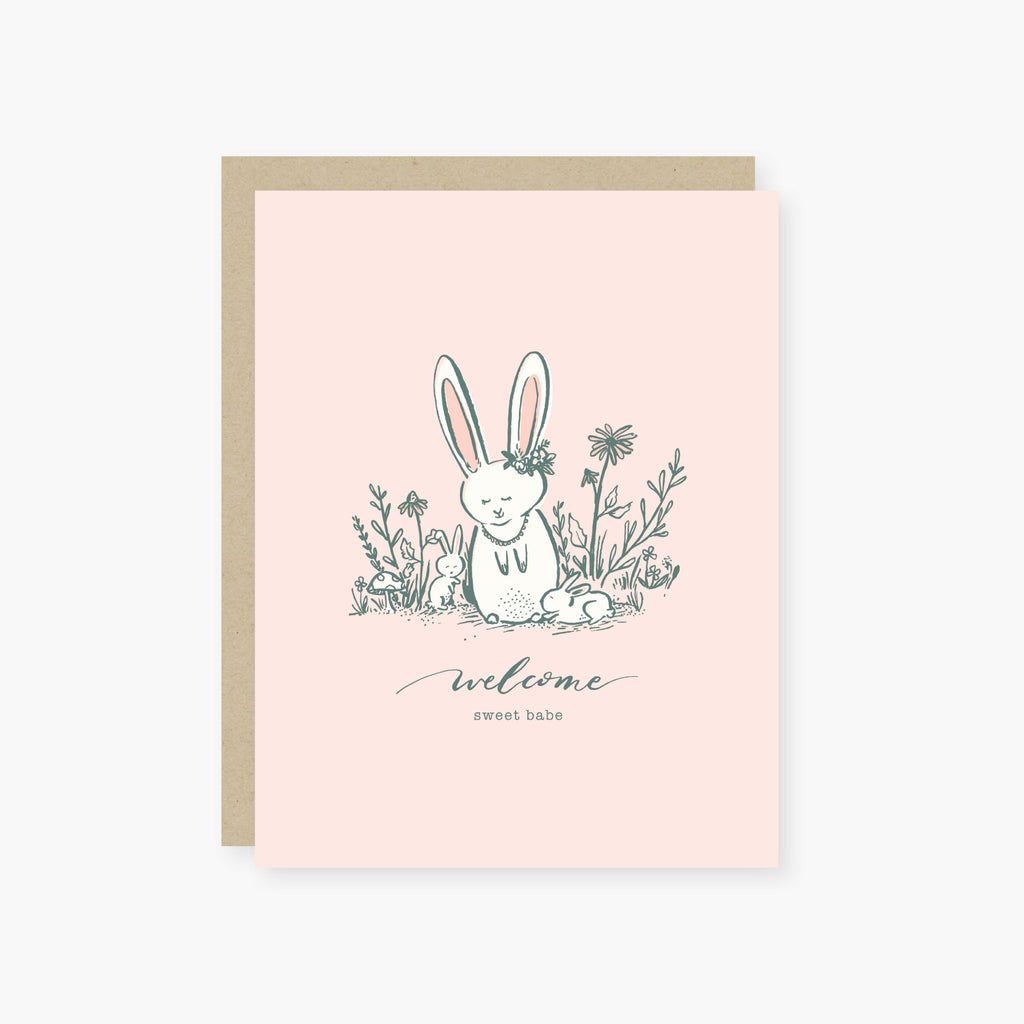 Greeting card with a bunny illustration and 'welcome sweet babe' text on a pink background