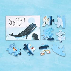 A children's jigsaw puzzle set titled 'ALL ABOUT WHALES' arranged on a light blue background. The set includes a rectangular puzzle piece with a whale illustration and title, several loose whale puzzle pieces, and a separate whale-shaped piece on the right.