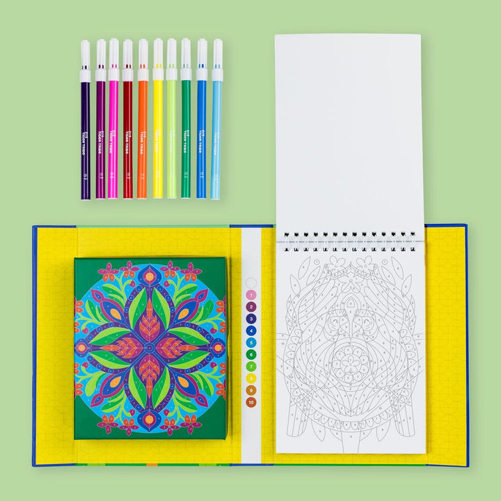 Coloring book with mandala design, markers, and a coloring page on a green background