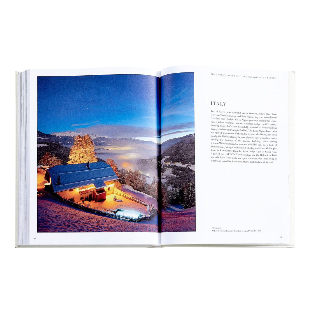 Open book showing a scenic view of a house with lights on a snowy landscape.