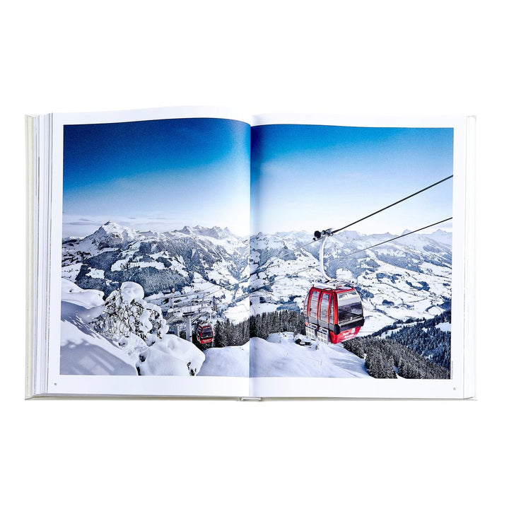 Open book showing a snowy mountain landscape with a red cable car.