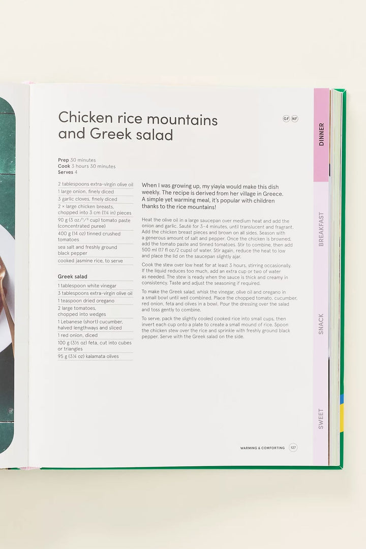 An open cookbook or recipe book showing a page for 'Chicken rice mountains and Greek salad' with a colorful tab system along the right edge labeled Dinner, Breakfast, Snack, and Sweet.