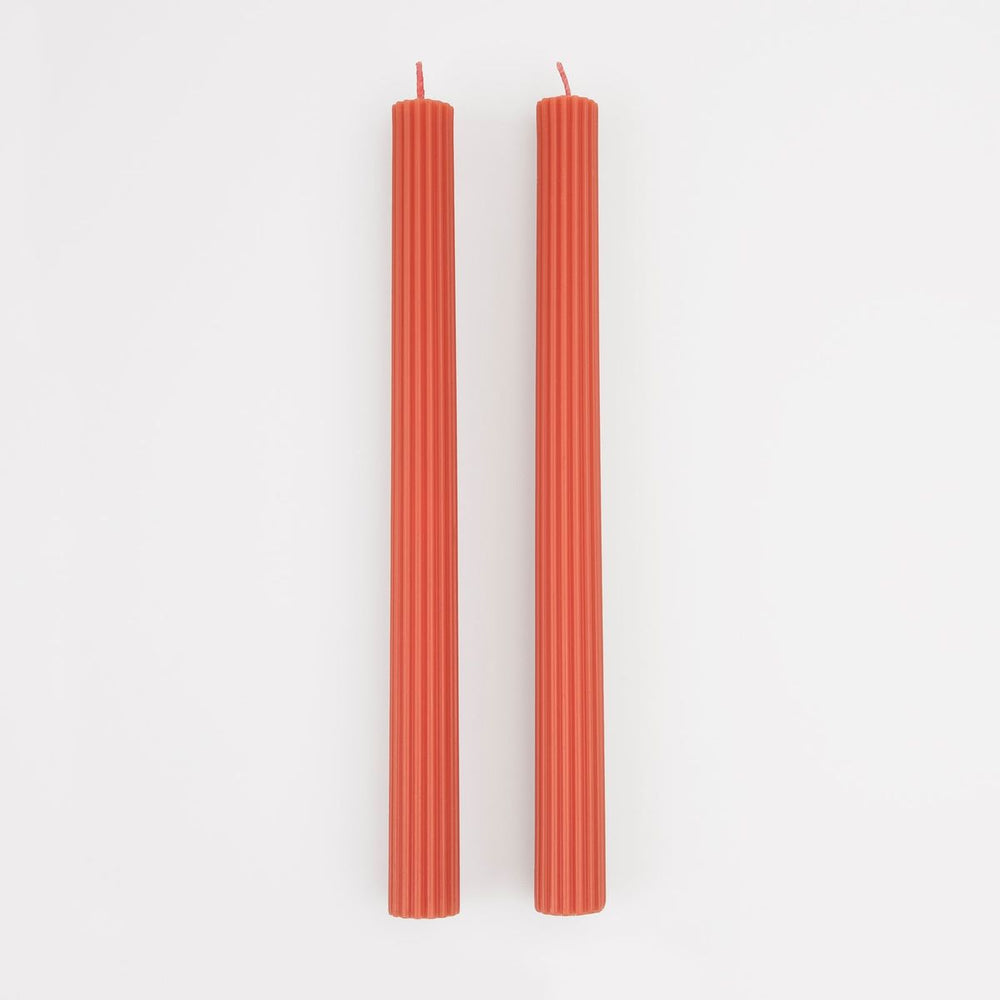 Two red candles on a white background
