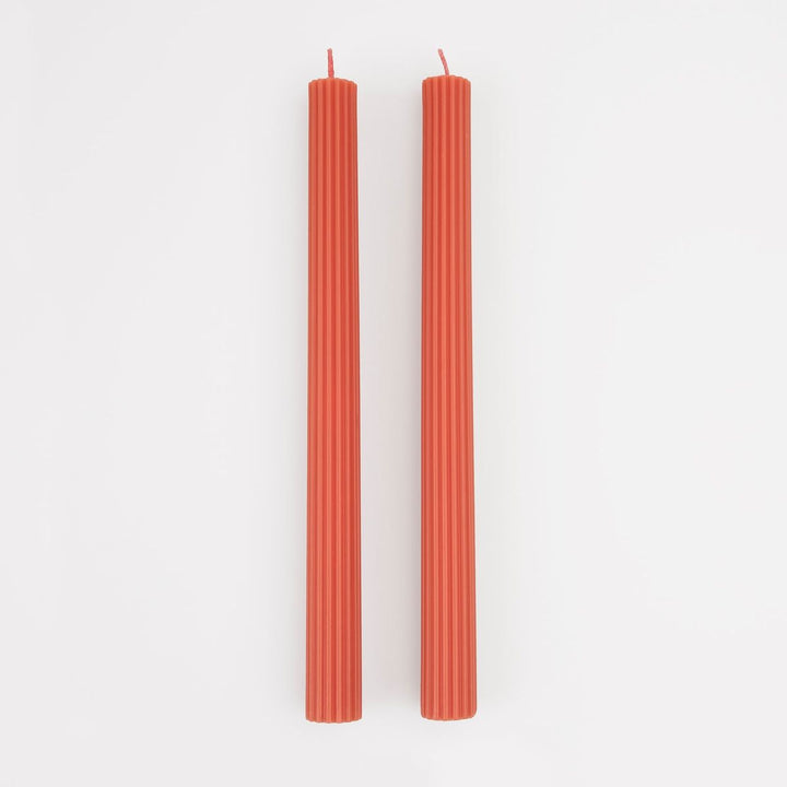 Two red candles on a white background