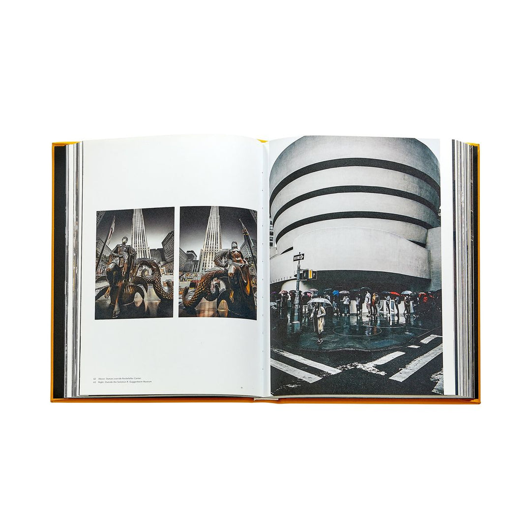 Open book showing a photograph of a building with people holding umbrellas on a rainy day.