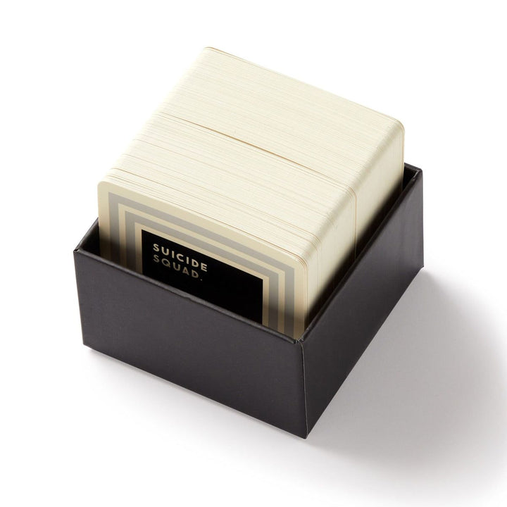 Stack of cards in a black box with 'Suicide Squad' branding on a white background