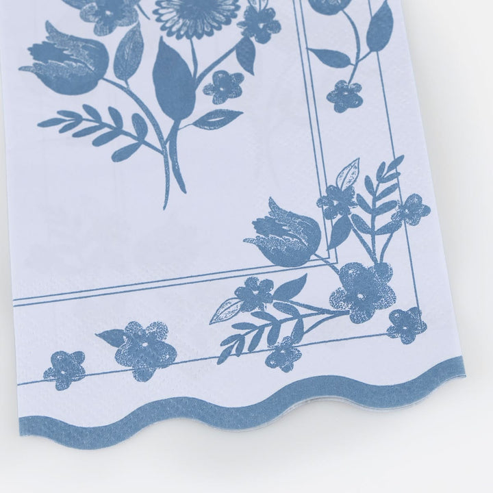 Floral patterned fabric with blue flowers and leaves on a white background