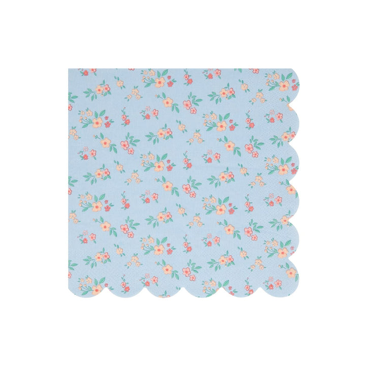 A square paper napkin with a scalloped edge, featuring a light blue background with a delicate repeating floral pattern in pink, orange, and green.