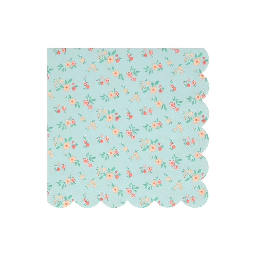 A square paper napkin with a scalloped edge, featuring a light blue-green background with a delicate repeating floral pattern in pink, orange, and green.