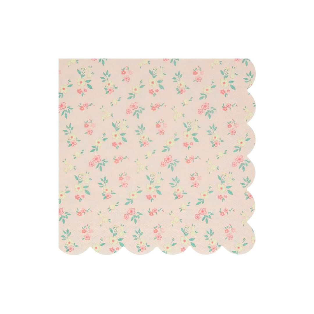 A square paper napkin with a scalloped edge, featuring a delicate pastel floral pattern on a light pink background.