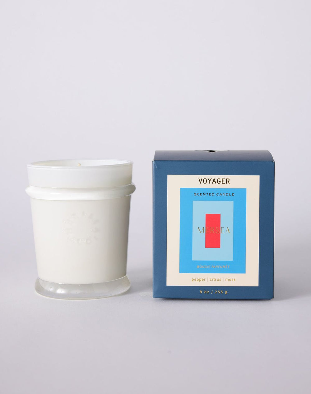 White candle with 'Voyager' packaging on a light gray background