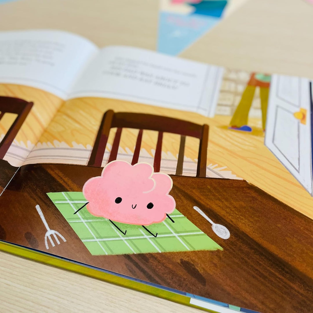 Illustration of a pink cloud character on a placemat with a book in the background